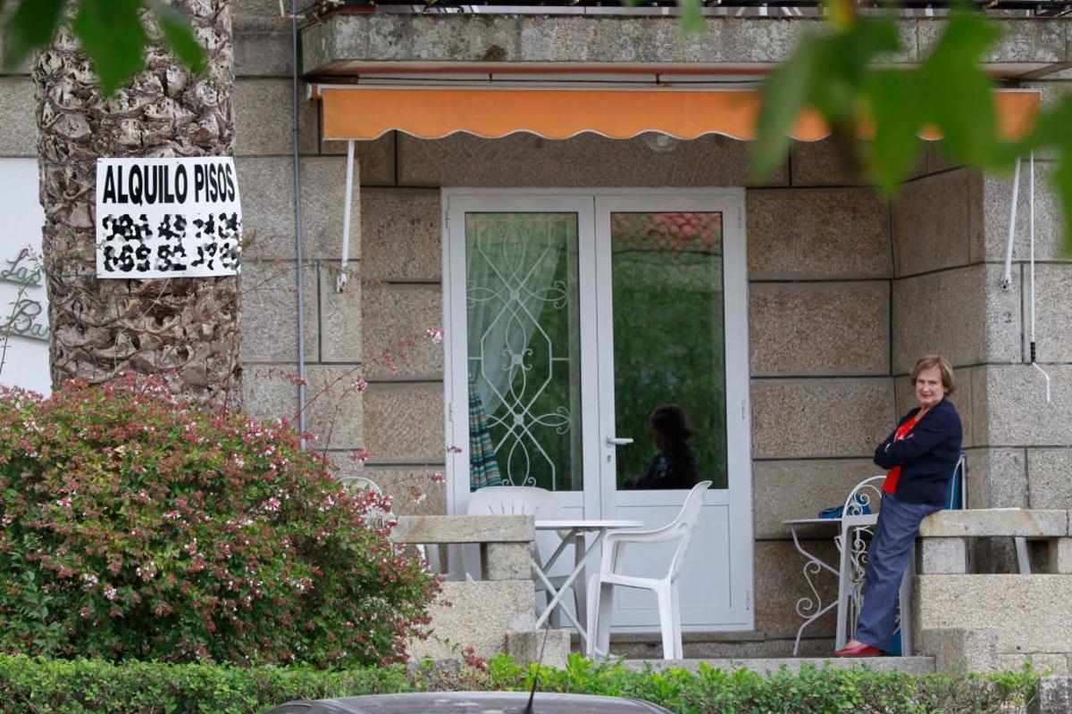 Una mujer en su casa   en Nigrán, con un anuncio de alquiler. // José Lores