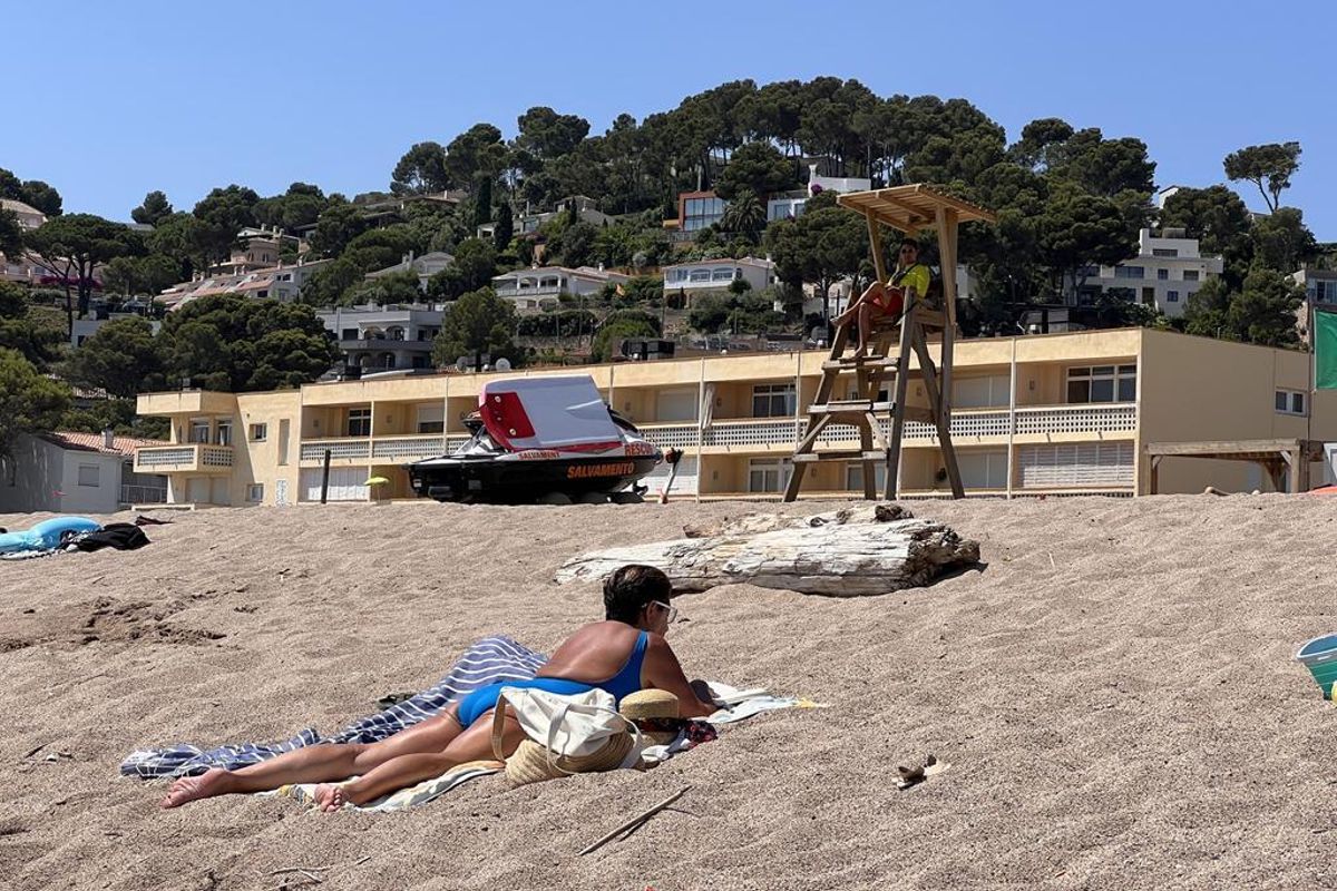 Una banyista a la platja de Pals amb un socorrista al fons