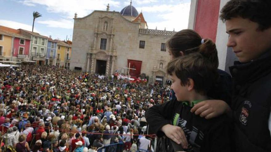 Una familia contempla a la multitud que llenó la plaza situada ante el monasterio de la Santa Faz, donde ayer se celebró la misa presidida por la Reliquia.