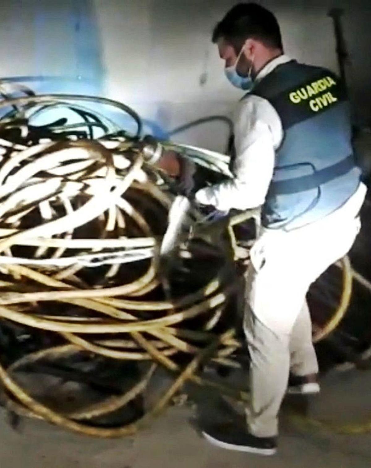 Un agente, con parte del material incautado | Guardia Civil