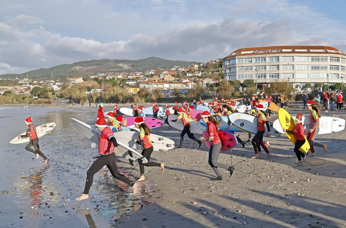Papá Noeles surfistas solidarios al agua en Patos