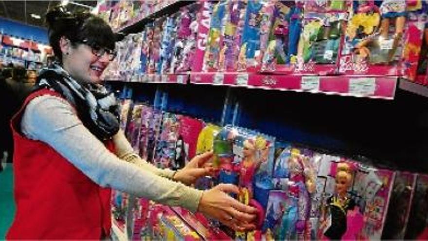 Sandra Gutiérrez, dependenta del Joguiba de la Pujada Roja, endreça els prestatges de la nina Barbie