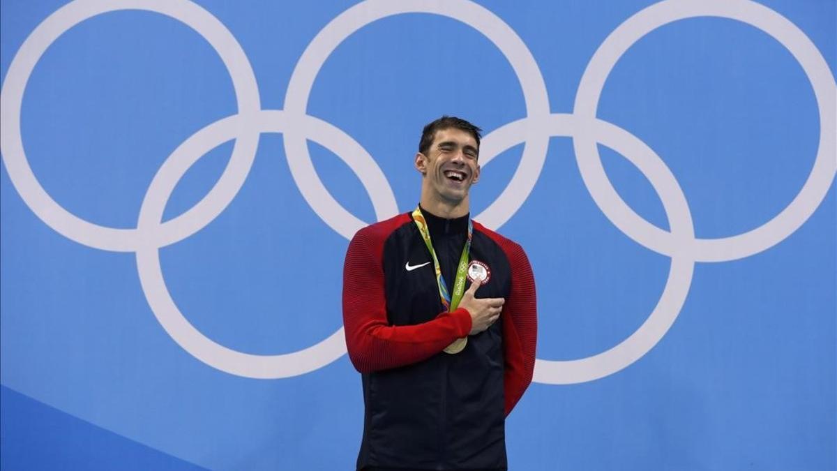 Phelps ríe en el podio con su nuevo oro con el que recupera el título olímpico en los 200 mariposa