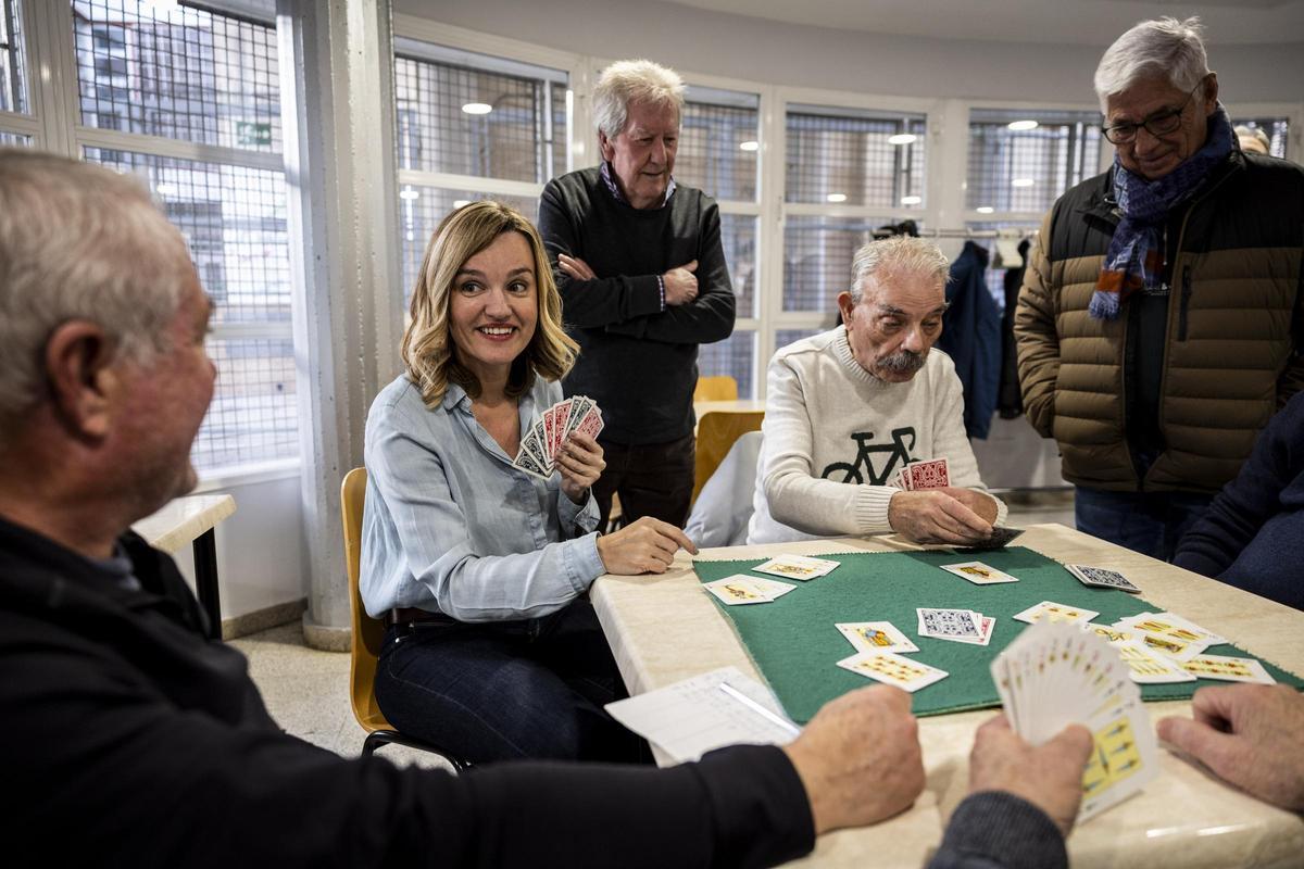 Pilar Alegría juega a las cartas con unos vecinos de Valdefierro, esta campaña electoral.
