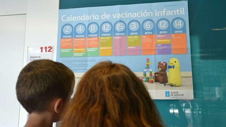 Una madre consulta con su hijo el calendario de vacunación infantil en el centro de salud de A Parda. // Gustavo Santos
