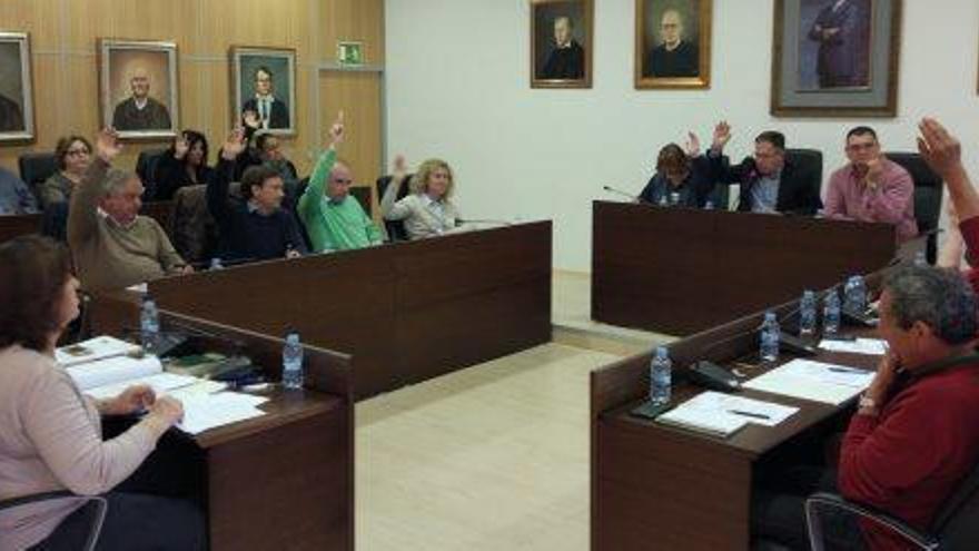 El equipo de gobierno y los concejales del PP levantan el brazo durante una votación en el pleno.