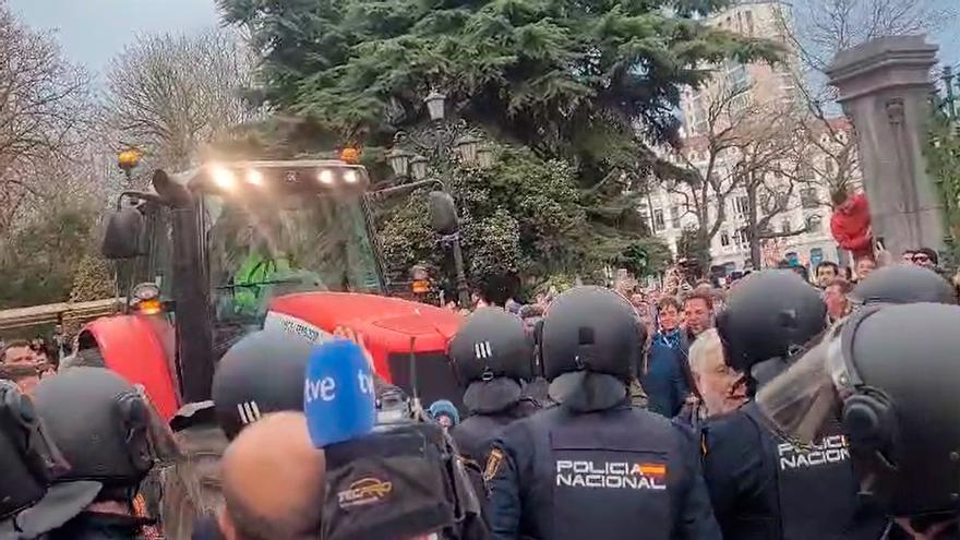 Los ganaderos tratan de romper el cordón de los antidisturbios con un tractor para acceder a la calle de Presidencia en Oviedo