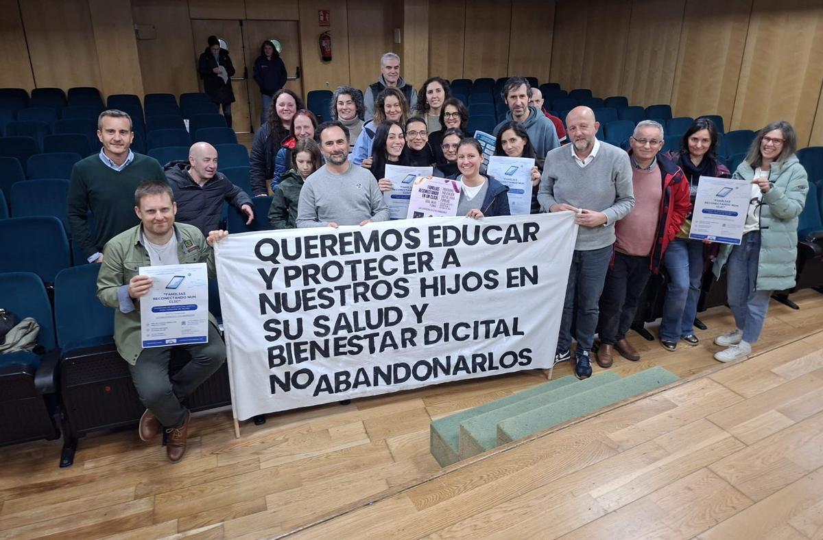 Padres que posaron con el cartel al final de la actividad. | TINO HERMIDA