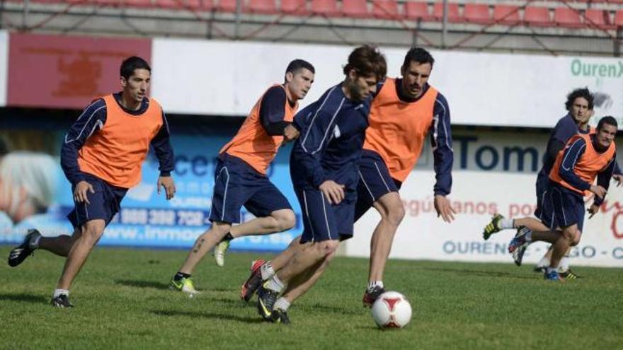 Adrián Quintairos controla un balón ante la atenta mirada del defensa central Capi, ayer, en el campo de O Couto. // Brais Lorenzo