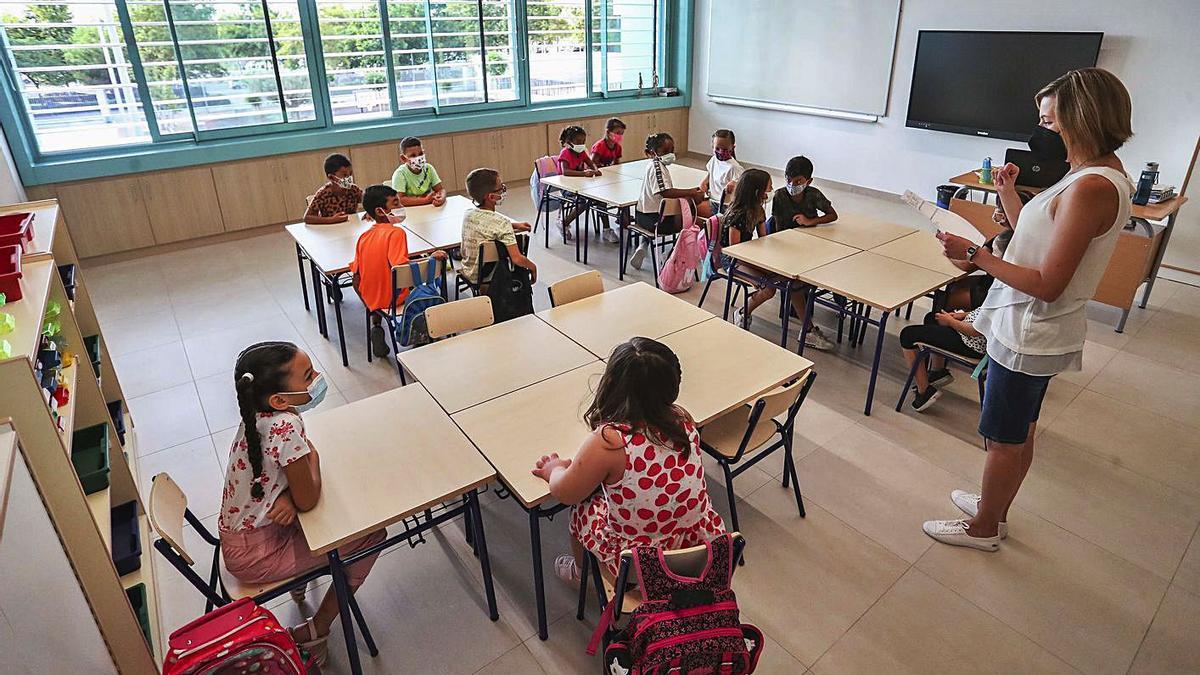 Una clase de Primaria atiende la explicación de la maestra, ayer en València. | FRANCISCO CALABUIG