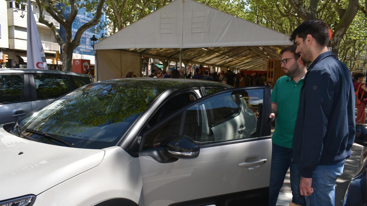 Xavier Comellas ensenya un vehicle exposat a uns clients