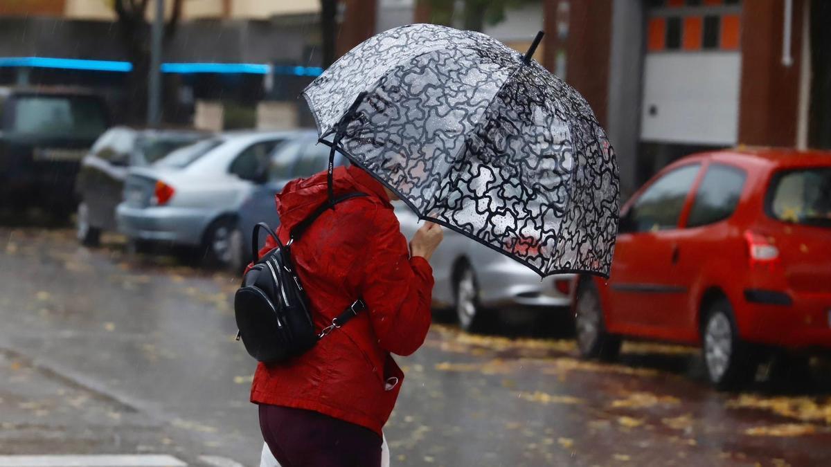 Una mujer se refugia de la lluvia bajo su paraguas en Córdoba, este fin de semana.