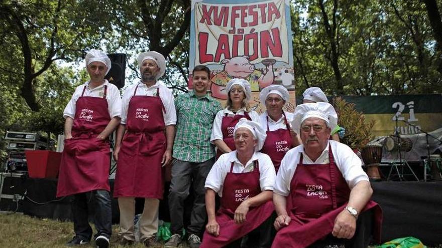 Directivos de la Asociación de Amigos do Lacón, ayer, con el cartel de la fiesta y su autor.