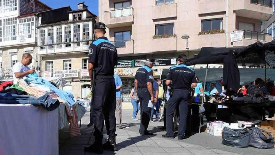 Policías locales supervisan los puestos del mercadillo ambulante en Ponteareas. // A. Hernández