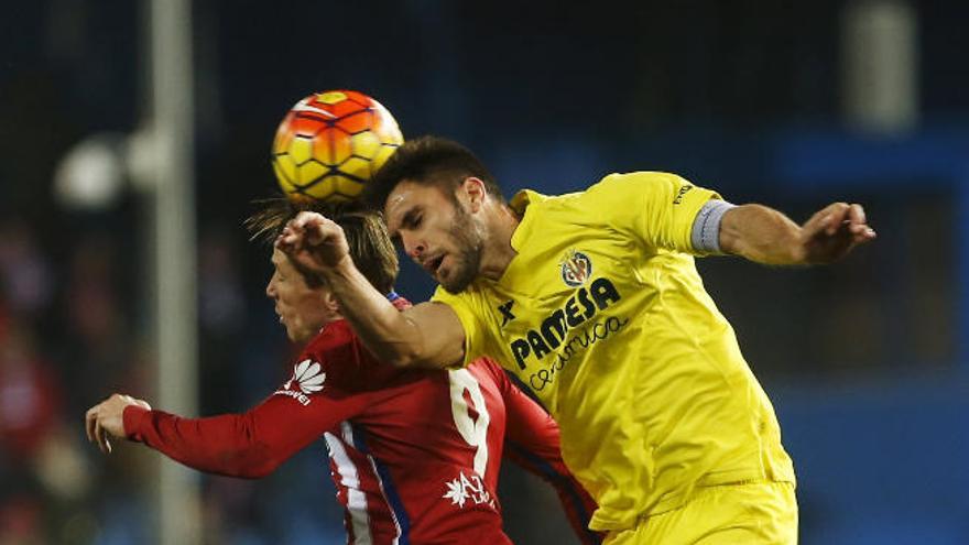 Víctor Ruiz (Villarreal) y Fernando Torres (Atlético), saltan a por un balón.