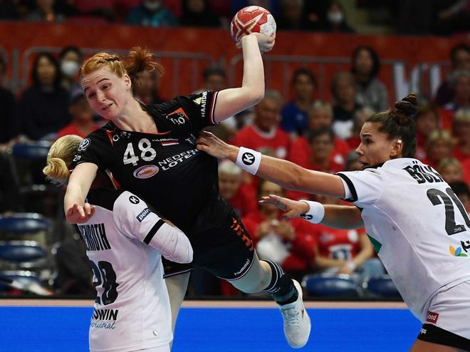 Antje Lauenroth (L) y Emily Bolk (R) de Holanda compiten por el balón con la alemana Dione Housheer (C) durante la ronda principal del grupo 1 partido entre Holanda y Alemania en el Campeonato Mundial de Balonmano Femenino en Kumamoto.