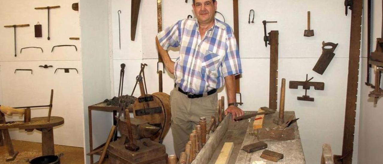 Javier Estrada se apoya en una mesa de carpintero instalada en la muestra.