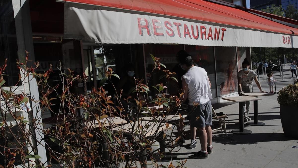 Los trabajadores de un restaurante de Boulogne-Billancourt, a las afueras de París, preparan la terraza para cuando se levanten las restricciones.