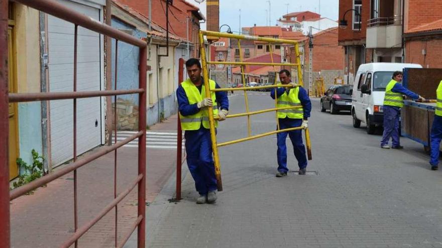 Varios operarios instalan vallas para los encierros urbanos.