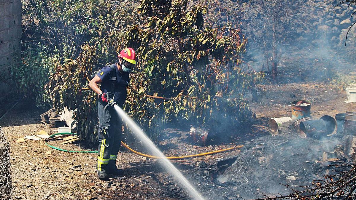 Un bombero de La Palma refresca una zona afectada por el incendio de la semana pasada. | | RAMÓN PÉREZ