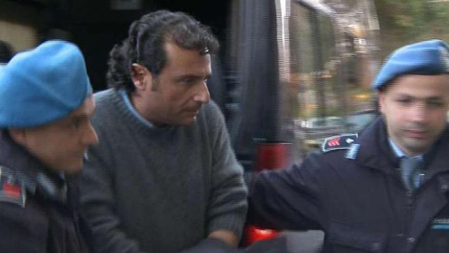 El capitán Schettino, flanqueado por carabineros, tras declarar ante la juez de Grosseto. / reuters