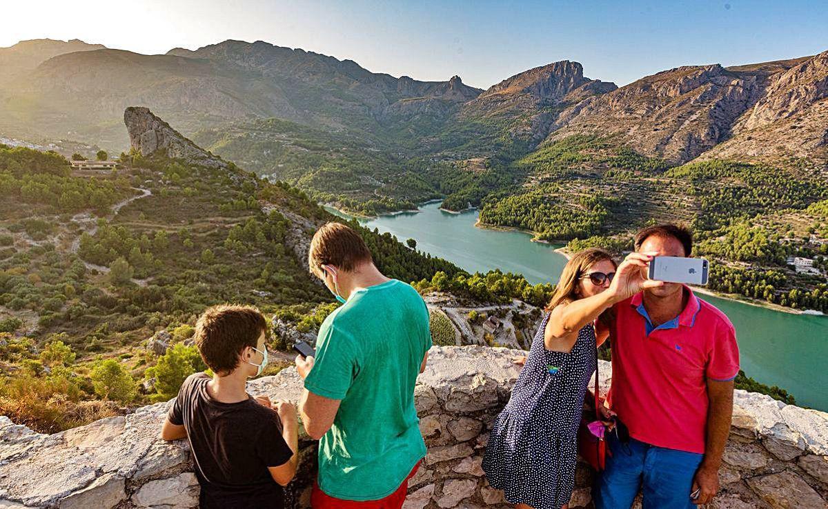 Un grupo de visitantes, en Guadalest, se hace fotografías.