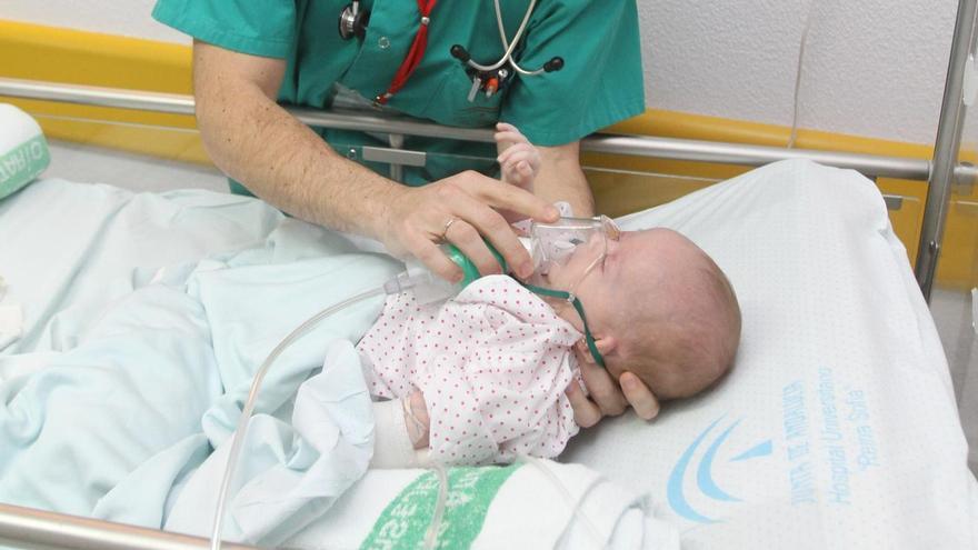 Un pediatra atiende a un bebé enfermo de bronquiolitis.