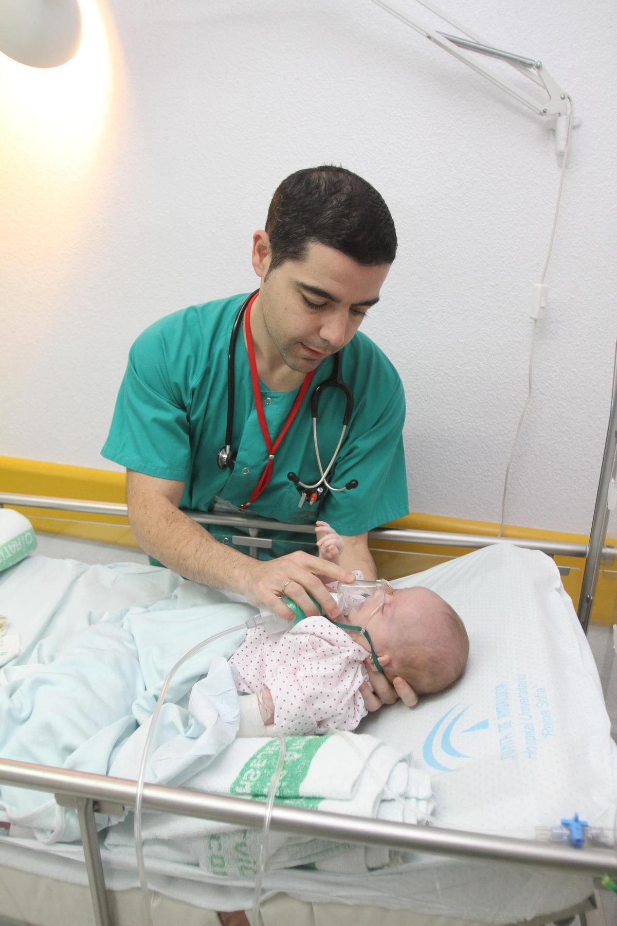 Un pediatra atiende a un bebé enfermo de bronquiolitis.