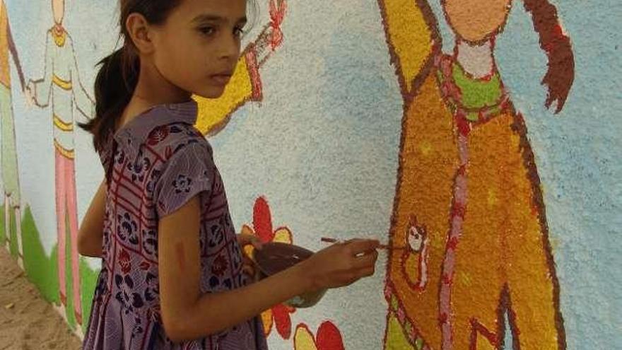 Otra niña, Stuti, pintándose a sí misma sobre la pared del mismo patio.