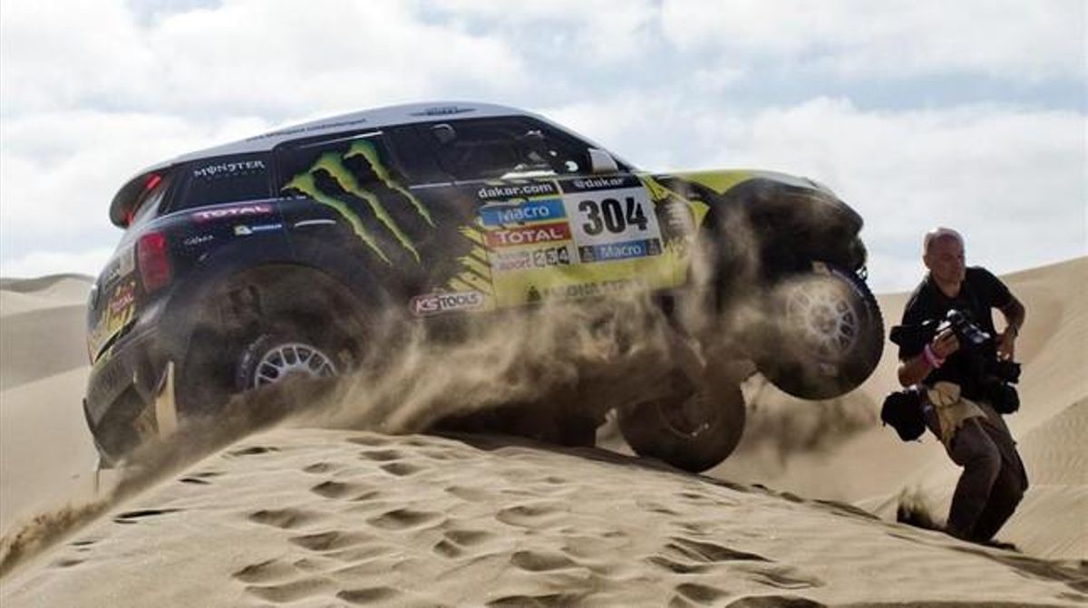 Un fotògraf esquiva el Mini de Nani Roma en la desena etapa del Dakar.