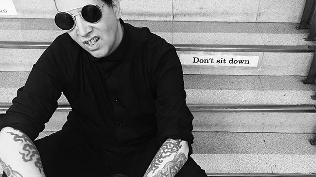 Marilyn Manson sentado en unas escaleras