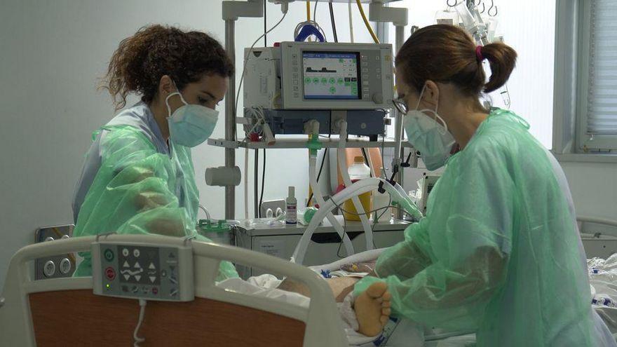 Dos sanitarias atienden a un paciente de covid