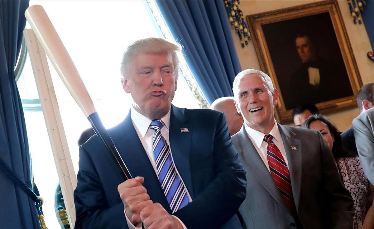 El vicepresidente, Mike Pence, ríe al contemplar a Donald Trump sujetando un bate de béisbol, en un evento en la Casa Blanca, el 17 de julio del 2017.