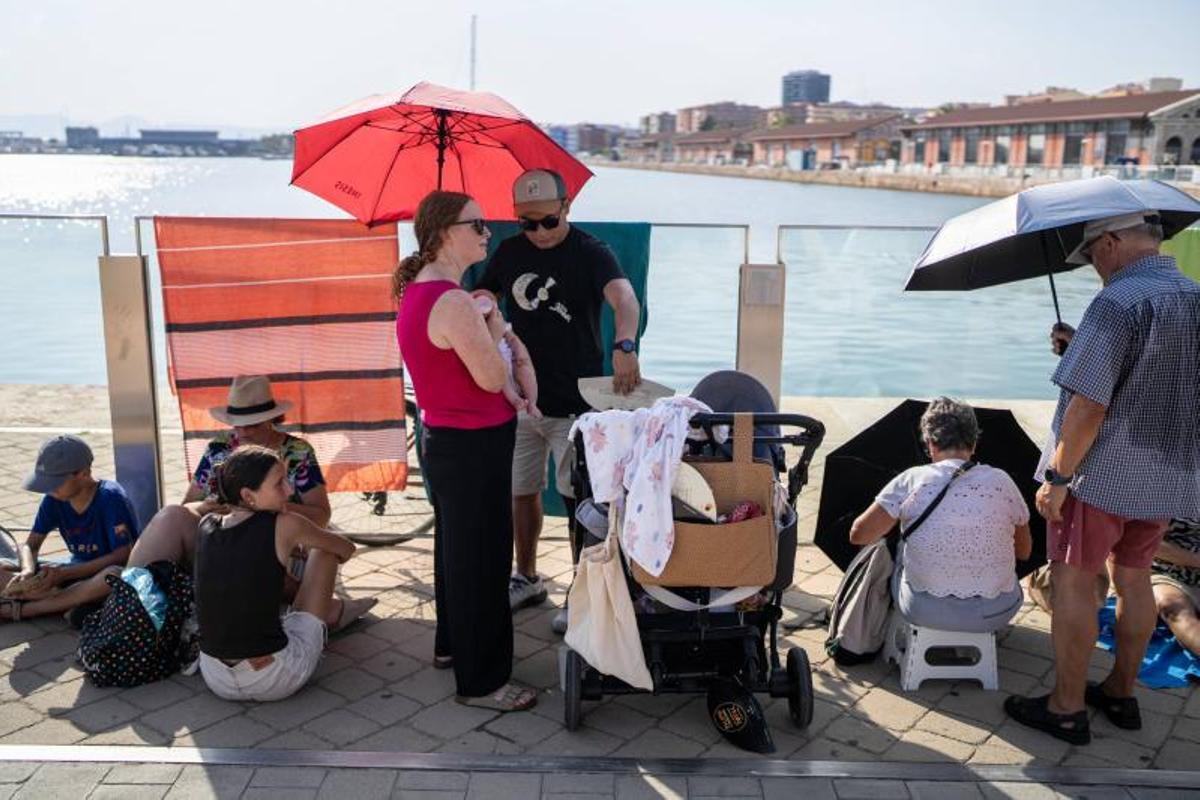 Visitantes y aficionados a la observación astronómica esperan en el Port de la Maria, en Tarragona, para contemplar el eclipse total de Sol.