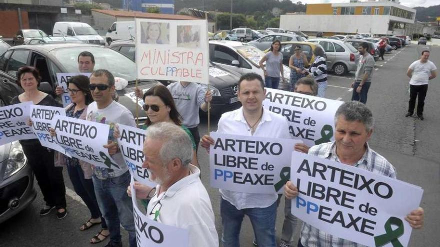 Vecinos de Arteixo, ayer, con carteles que repartió la plataforma contra el peaje de Pastoriza.