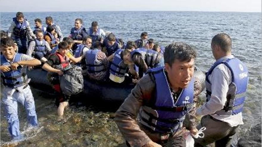Refugiats afganesos salten d&#039;una embarcació plena de gom a gom després d&#039;arribar a l&#039;illa de Lesbos, ahir.