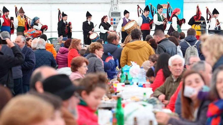 La multitudinaria comida, amenizada por música asturiana. Abajo, los comensales disfrutan de la fabada.