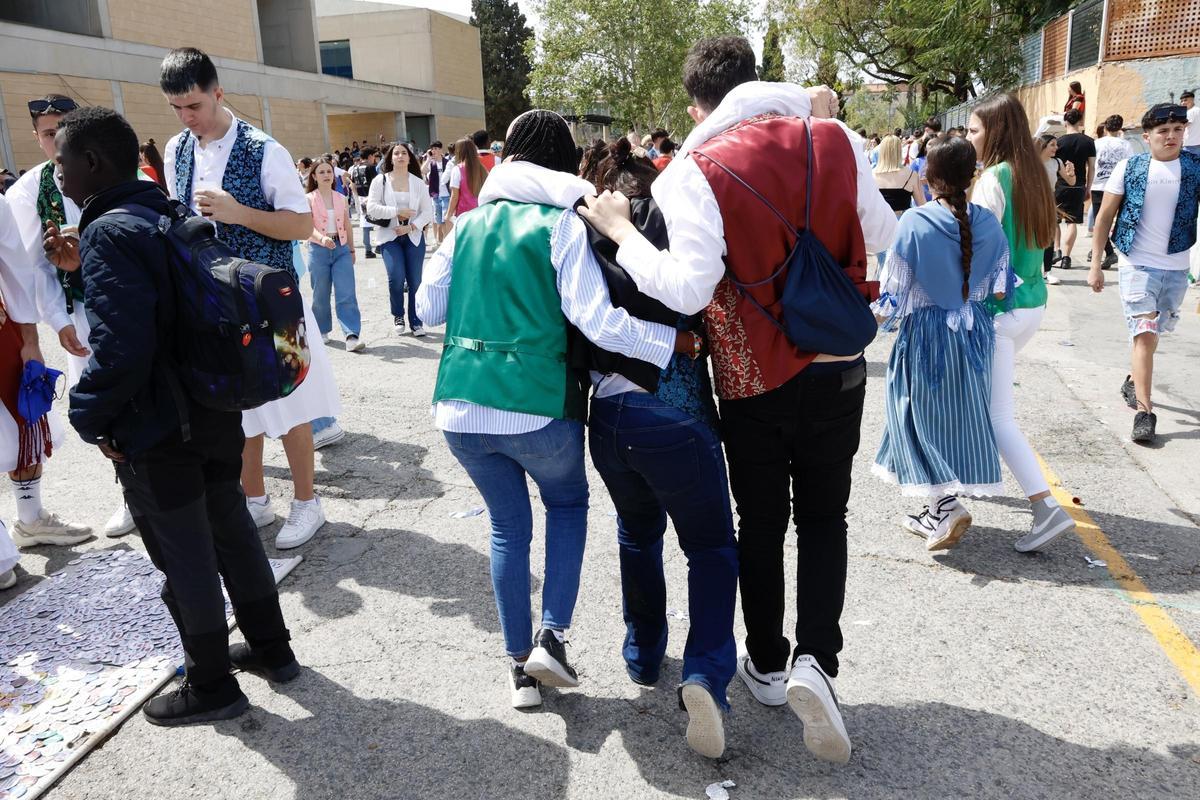 Dos personas sostienen durante el Día del Bando de 2024 a una joven que se sentía indispuesta.