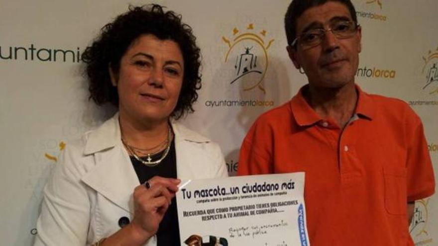 La edil muestra el cartel de la campaña sobre cuidado de mascotas.