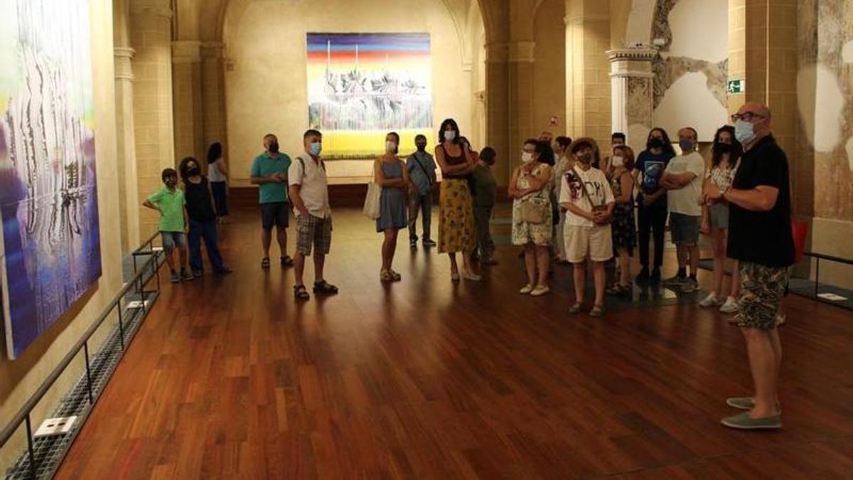 Julián Mesa, promotor del proyecto Arteria, explica a los visitantes una de las obras de Felicidad Moreno.