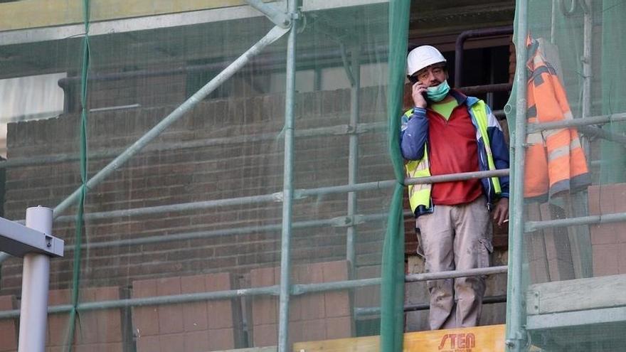 Trabajadores de la construcción en un andamio cerca de la Ronda de Dalt de Barceloba, ejerciendo durante la actual pandemia del coronavirus.