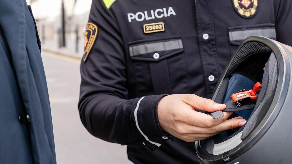 Un agente de la Guardia Urbana de Barcelona sujeta un casco de moto