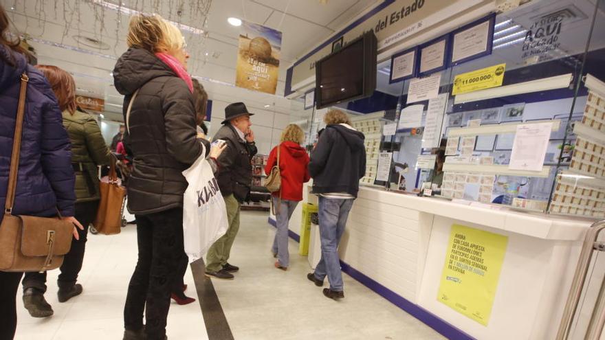 Alicantinos comprando lotería en una administración