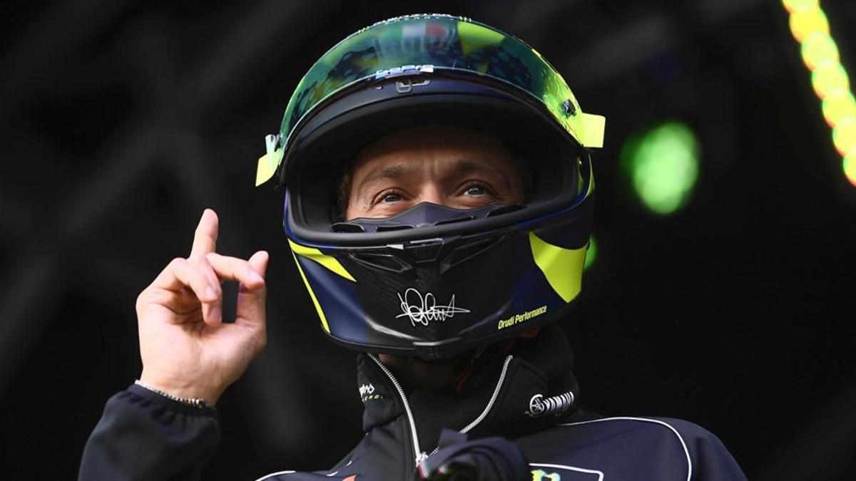 Valentino Rossi se pone su casco antes de subastarlo, en Silverstone, para que todo el mundo vea que es el suyo.