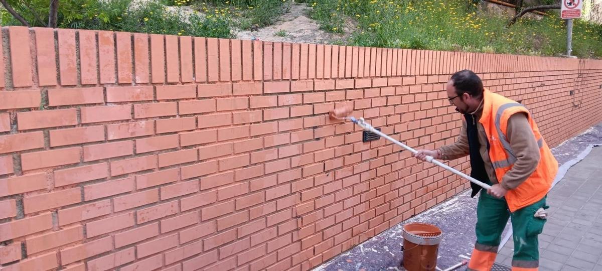 Un operario de limpieza de Paterna borra una pintada.