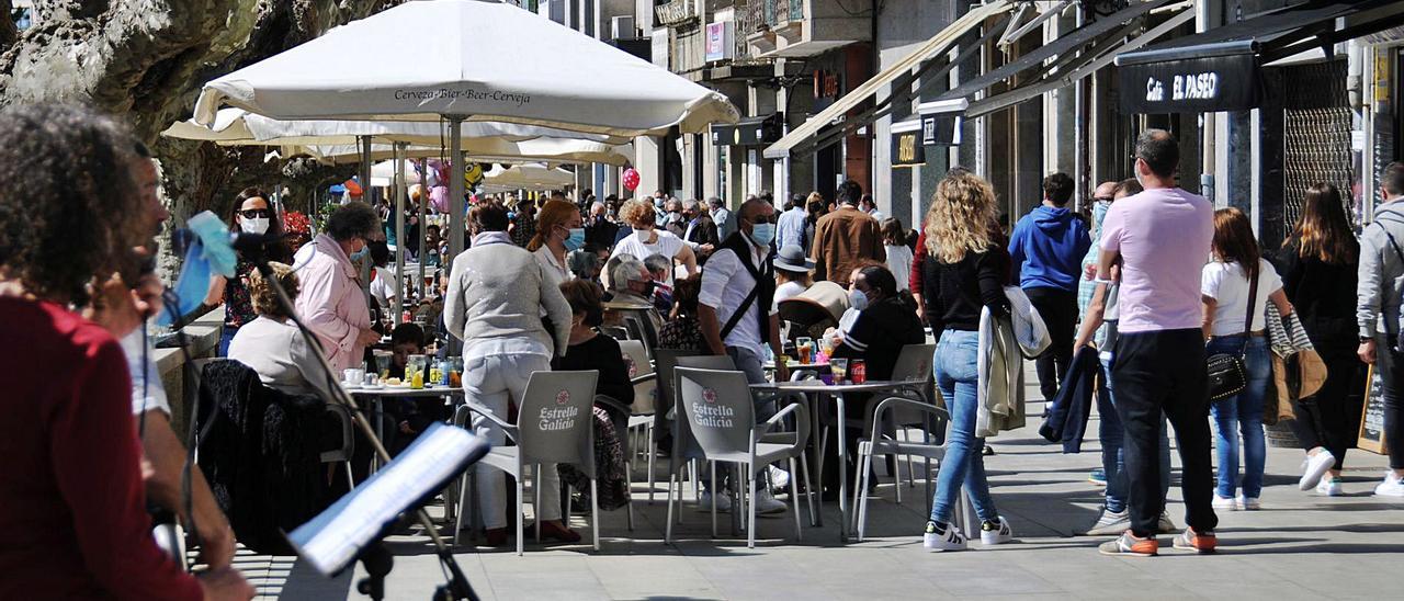 Centenares de personas disfrutando de las terrazas en la calle Eugenio Sequeiros, de Cangas, ayer a mediodía.   | // G.NÚÑEZ