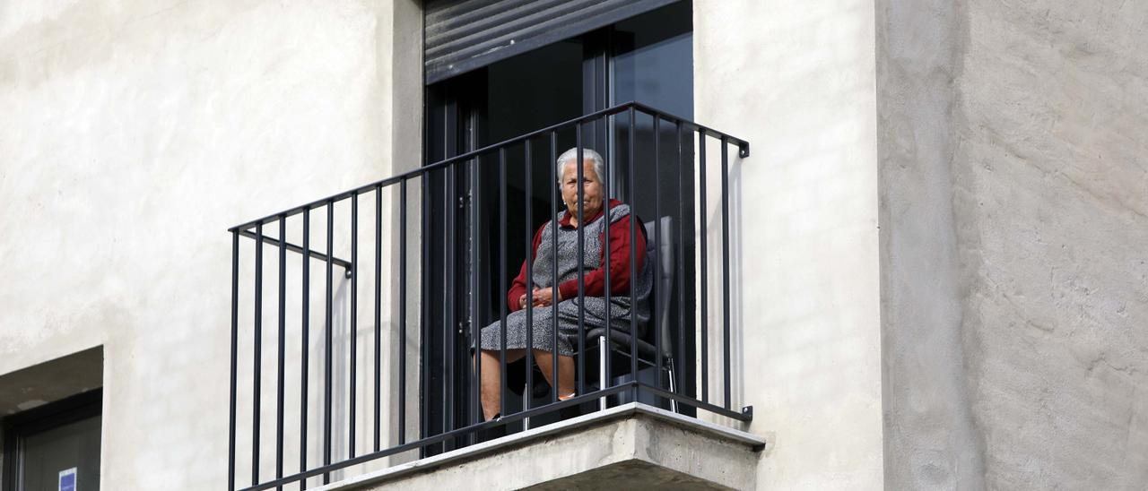 Una mujer en un balcón durante el confinamiento domiciliario de 2020.
