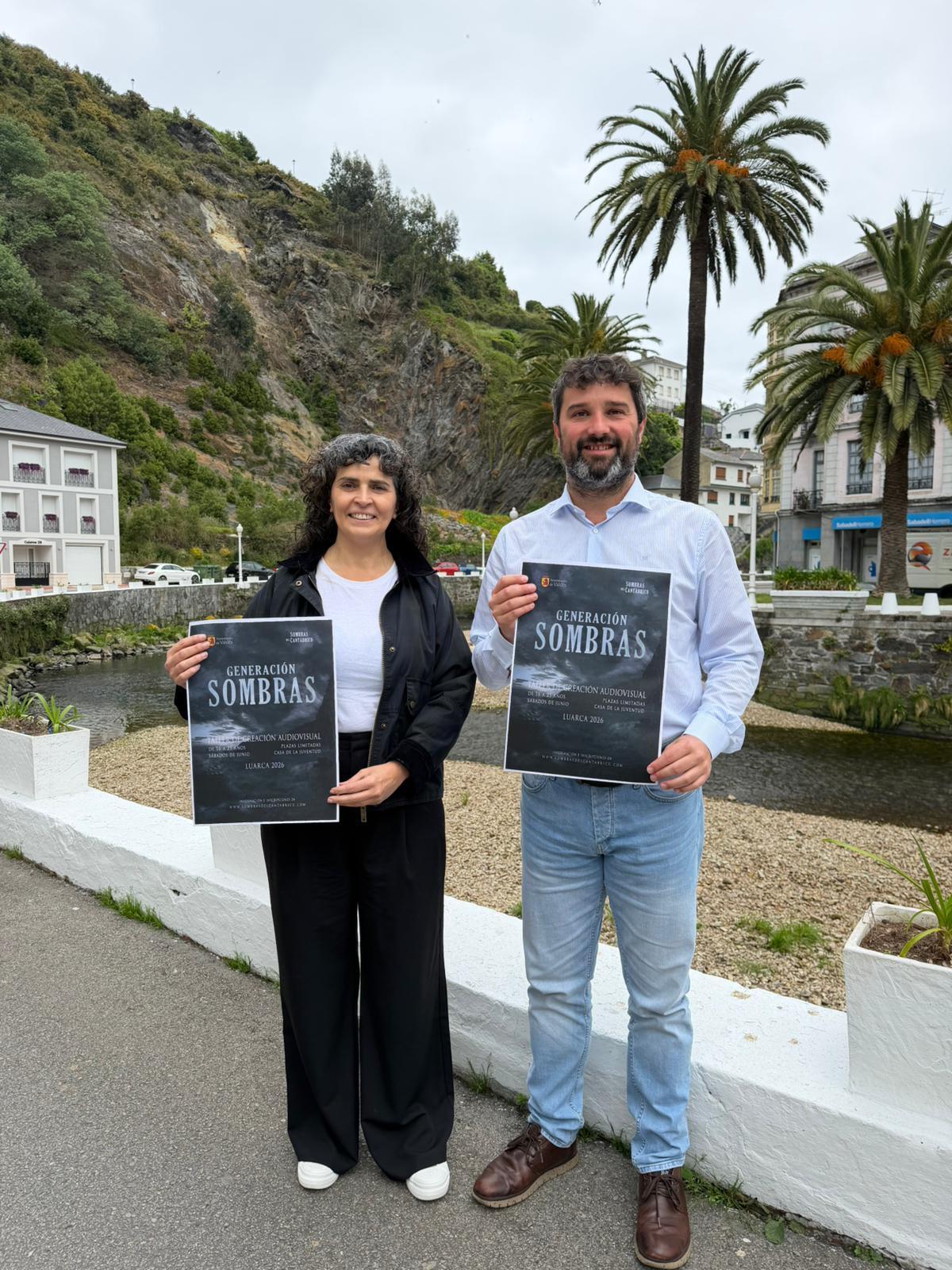 La concejala de Infancial, Clara García, y el alcalde, Óscar Pérez, con el cartel que anucia los talleres.