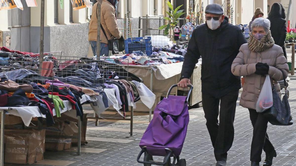 Una parella passejant, ahir, pel mercat de Calaf | JORDI BIEL