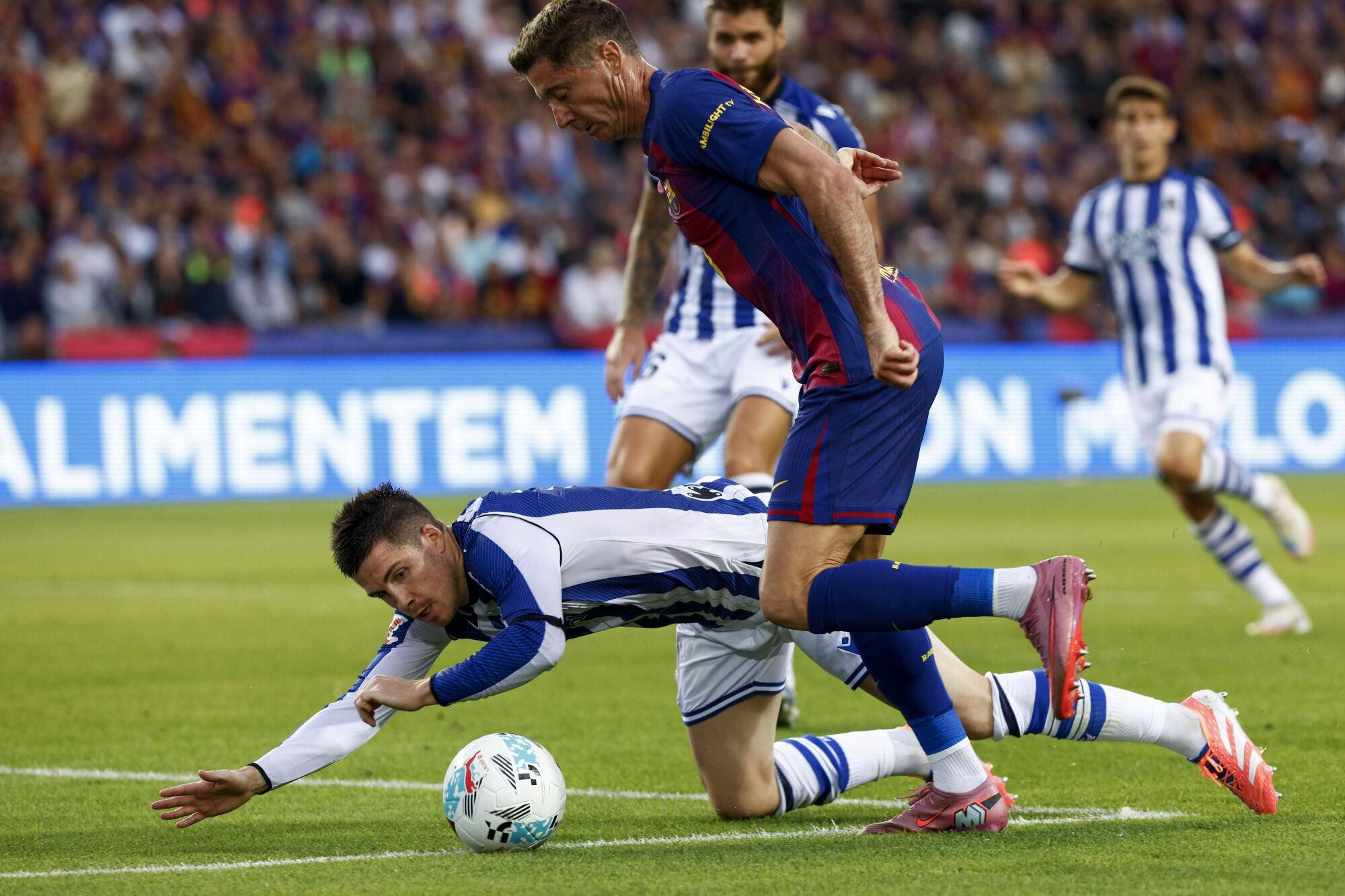 FC Barcelona's Polish forward Robert Lewandowski (R) takes the ball past Real Sociedad midfielder Igor Zubeldia during the La Liga match between FC Barcelona and Real Sociedad at the Montjuic Stadium, Barcelona, Spain, 28 September 2025. EFE/ Quique Garcia
